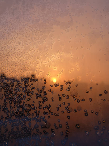 istock Background image. Frost patterns on glass. Dawn. Orange and pink tones. 1289366733