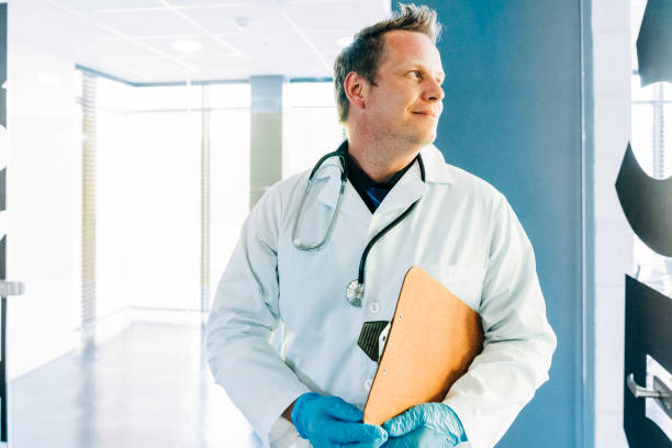 istock Male surgeon looking away while holding clipboard 1289367705