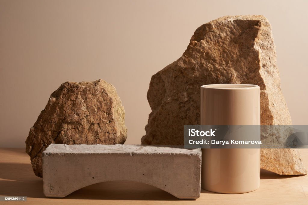 Stone and a piece of tile podium on a beige background Beige stone and a piece of gray podium tile on a beige background, natural background for your product Merchandise Stock Photo