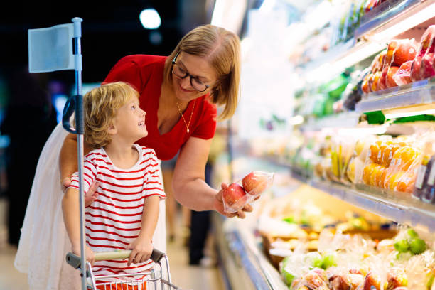 mãe e filho comprando frutas no supermercado. - carrinho de criança - fotografias e filmes do acervo