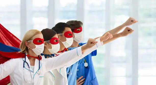 Photo of Doctor or nurse in face mask and superhero cape.