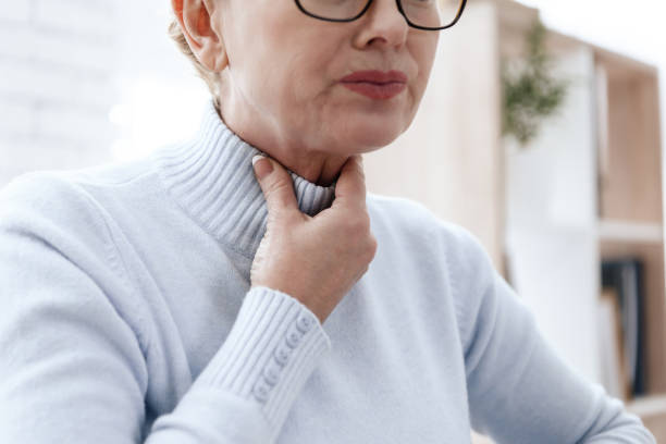 A woman has a sore throat. stock photo