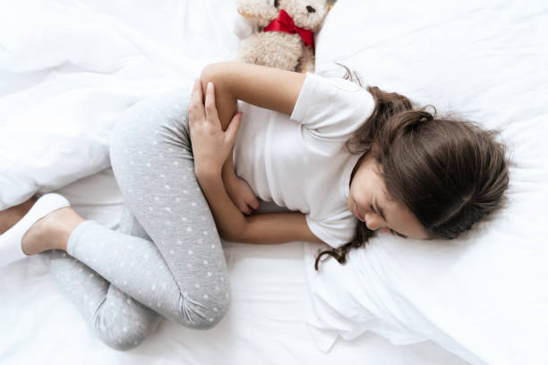 The girl has a stomach ache. The girl has a stomach ache. She feels bad and uncomfortable, then that it hurts. She holds her hands in her sore spot. stomachache stock pictures, royalty-free photos & images