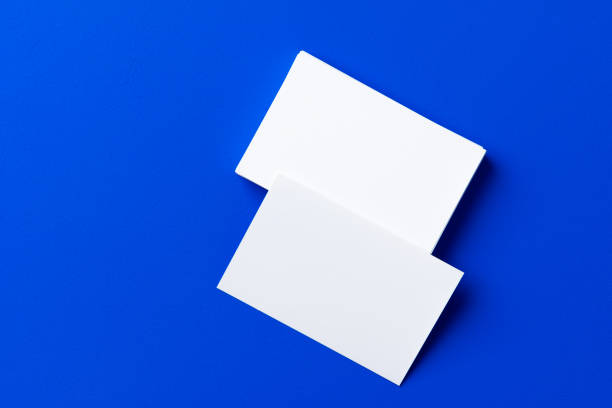 istock Blank white businesscards on classic blue background 1289373558
