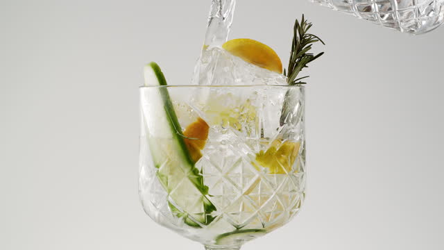 Pouring in gin and tonic in glass