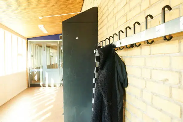 coat rack in a school hall with jacket hanging on it