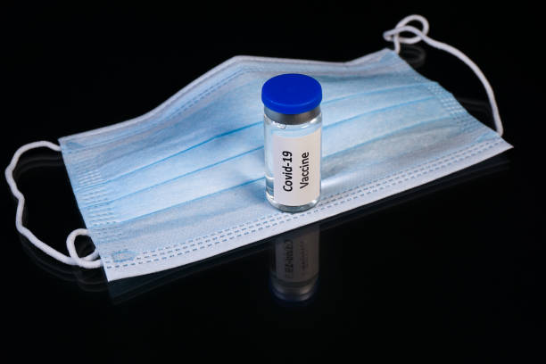 istock Covid-19 vaccination vial on a surgical face mask 1289376477