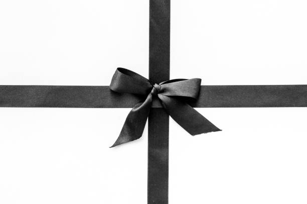 istock Festive black ribbon with bow isolated on white. Top view, copy space 1289376498