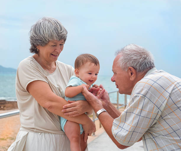 happy family on a walking happy family on a walk.  Grandmother holds the baby, great grandfather plays with the child on the embankment. 3 6 months stock pictures, royalty-free photos & images