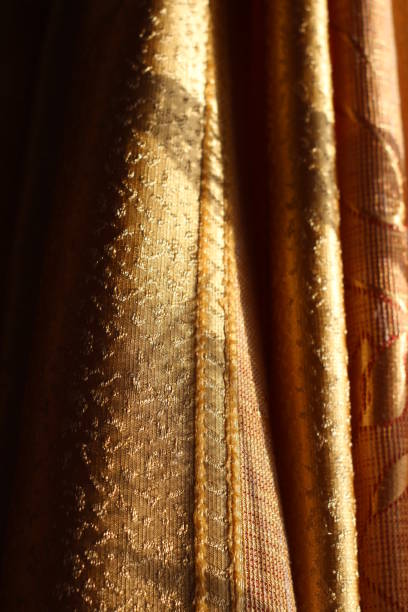 istock Curtains Texture Close-up Textile Design Golden Colored Fabric in Sunlight 1289377801