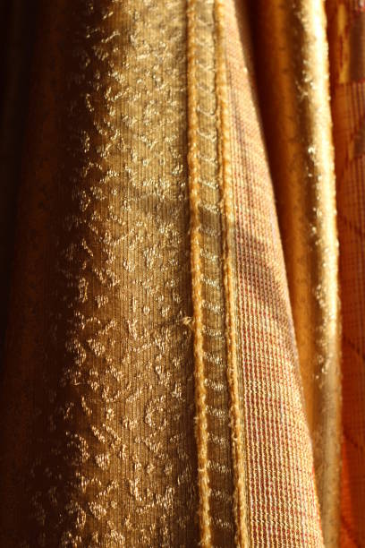istock Curtains Texture Close-up Textile Design Golden Colored Fabric in Sunlight 1289378729
