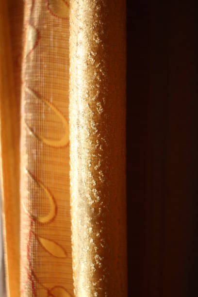 istock Curtains Texture Close-up Textile Design Golden Colored Fabric in Sunlight 1289378919