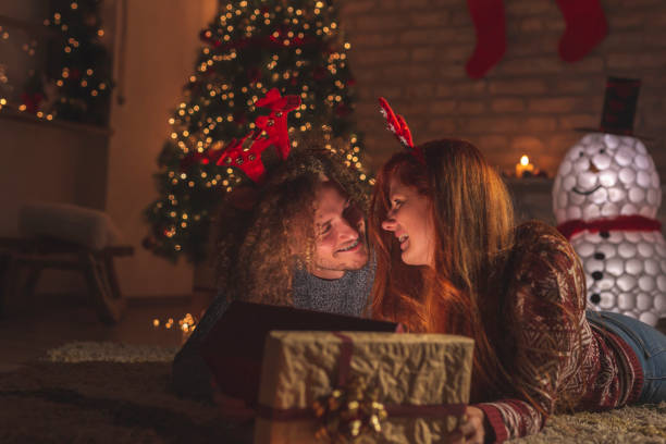 istock Couple opening presents for Christmas Eve 1289380798