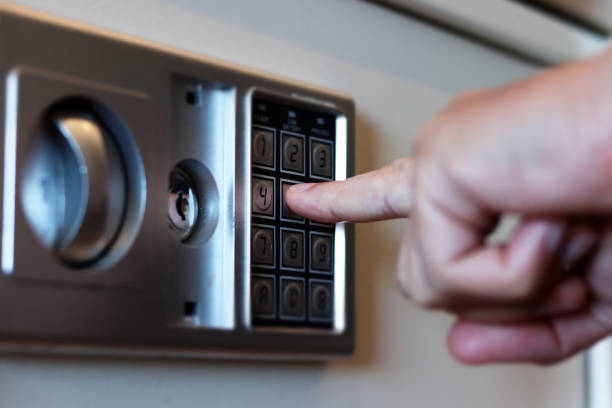 coffre-fort brouillé avec la serrure de combinaison et la main humaine dans une chambre d’hôtel, nombres de plan rapproché avec l’effet de décalage d’inclinaison. mise au point sélective - combination lock photos photos et images de collection