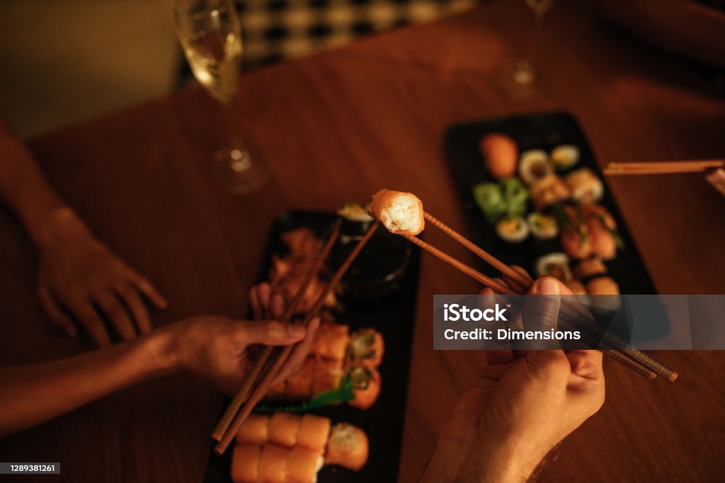 Nothing like dinner at home Shot from above of two people eating sushi. Sushi Stock Photo