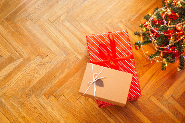 istock Christmas presents and decorated tree, gift boxes and christmas tree with lights on the floor with copy space for text 1289383510
