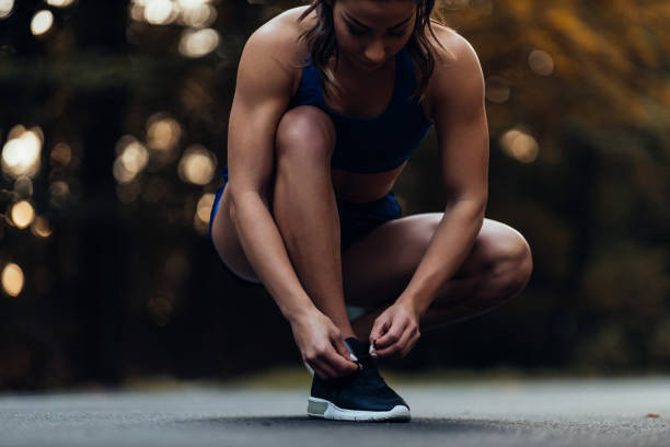 istock Athlete woman tying her shoes 1289384567
