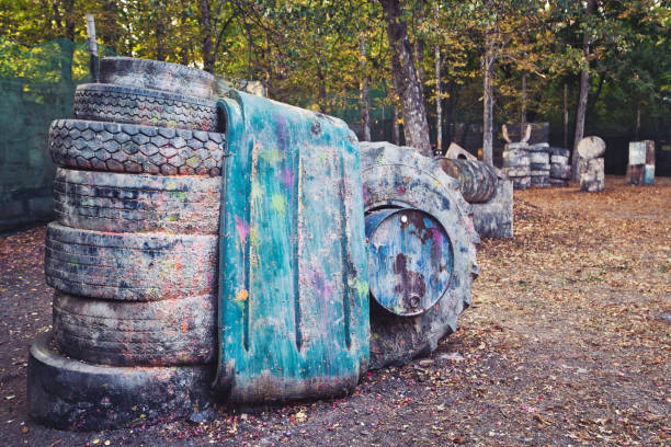 Old rusty barrels and damaged tires on a paintball base Old rusty barrels and damaged tires at the paintball base where the excited players are hiding paintball photography stock pictures, royalty-free photos & images