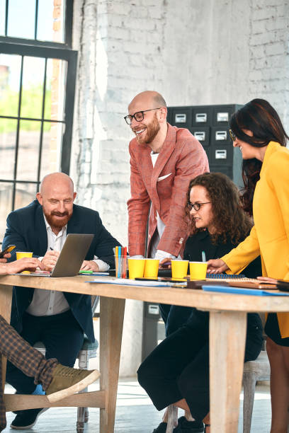istock Beautiful business people are using gadgets, talking and smiling during the conference in office. Selective focus 1289384580