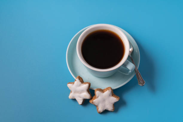 istock Cup of coffee on blue background, with cookies, copy space for text 1289385455