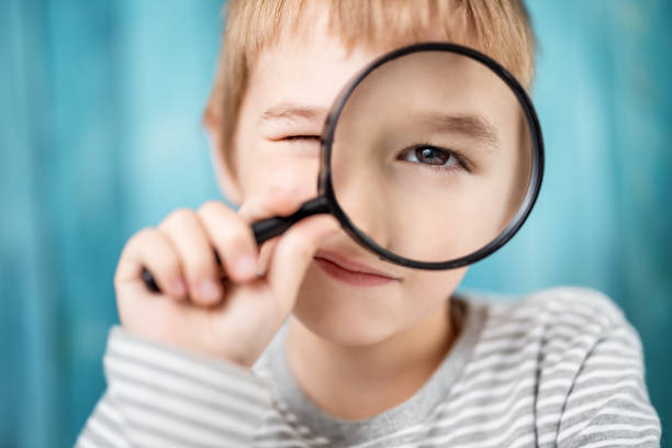 istock Little boy looking through a magnifying glass 1289387075