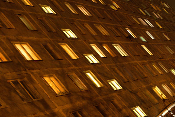 istock Facade of an apartment building with luminous windows at night. 1289388582