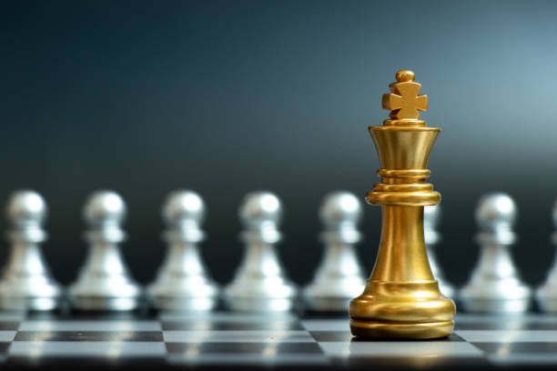 istock Gold king chess piece face with silver team on black background (Concept for company strategy, business decision and encounter the problem) 1289389595