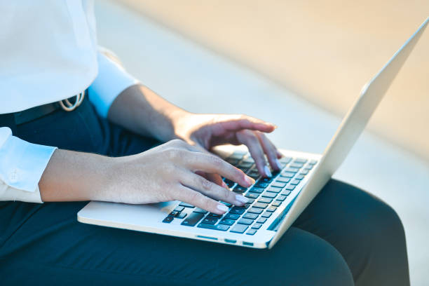 istock Girl using a laptop outdoors 1289389673