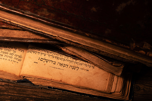 Old worn jewish books on open page of Makhzor with traditional Jewish prayer L'Shana Haba'ah B'Yerushalayim that means Next year in Jerusalem. Concept of desire to return to a rebuilt Jerusalem