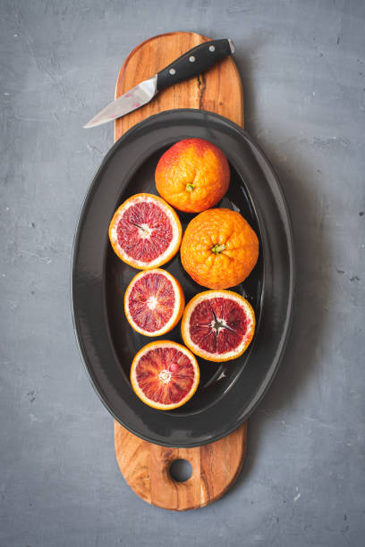 istock Fresh bloody oranges on a black plate on a dark gray background 1289390119