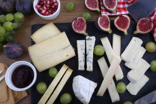 cheese board cheese table with diferent types of french and swiss cheese plate fig blue cheese cheese stock pictures, royalty-free photos & images