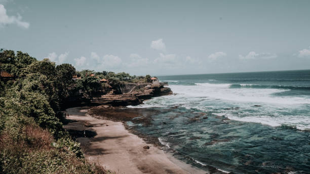 istock cliff with rocky beach with many waves in bali 1289393086