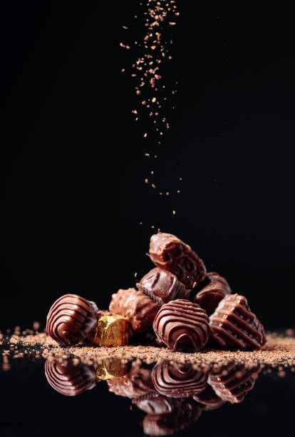 istock Various chocolate candies on a black background sprinkled with chocolate chips. 1289396599
