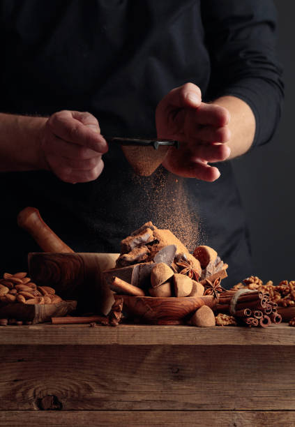 The cook sprinkles the chocolates with cocoa powder.