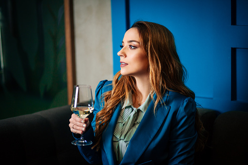 Woman Wearing Business Suit And Tasting White Wine