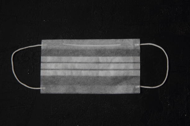 istock Disposable medical mask isolated on black background 1289404869