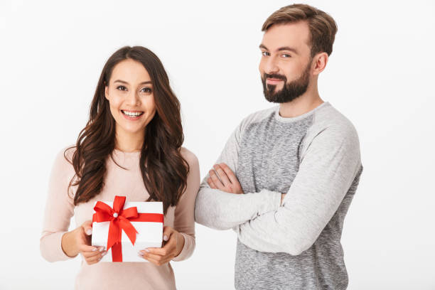 istock Happy young loving couple holding gift present box. 1289408592