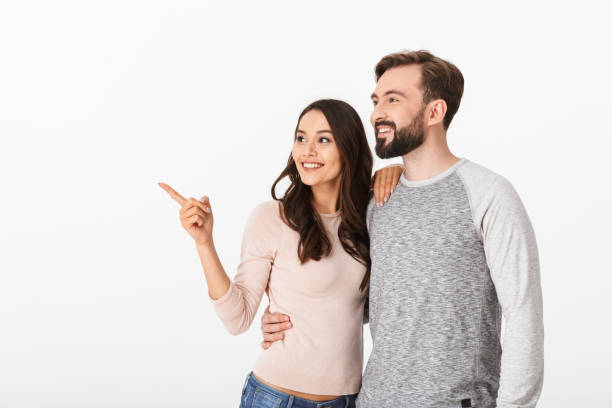 istock Cheerful young loving couple pointing. 1289409037