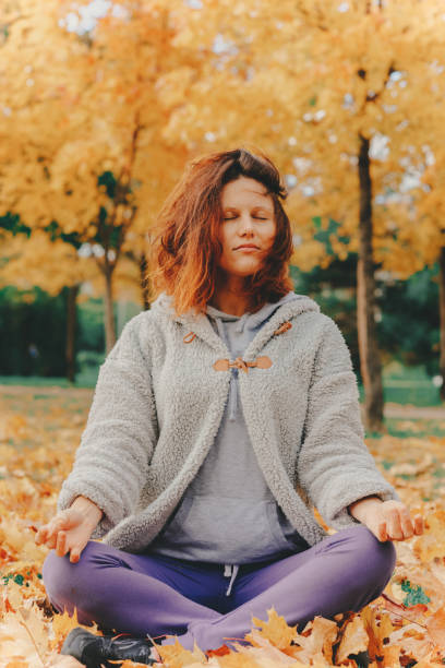 istock Girl meditates while sitting in the park. 1289409804