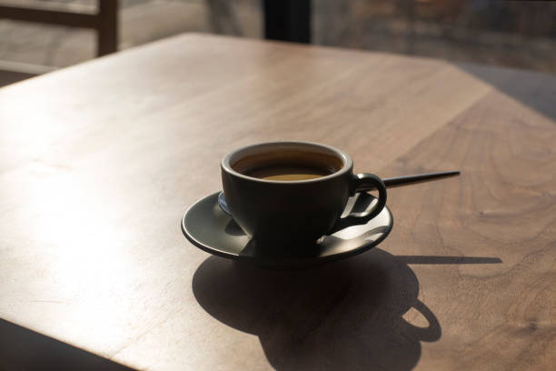 istock cup of espresso with shadow on wooden table. 1289409853