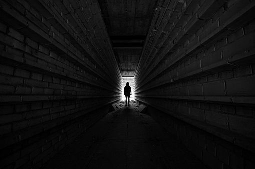 Person standing in the light at the end of the tunnel