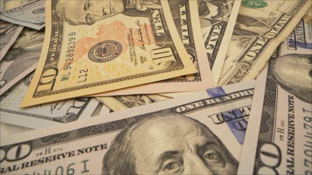 istock A pile of one hundred US dollar bills on a table. Dollars on the table 1289410351