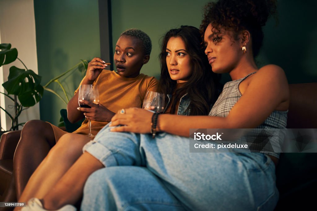 We end the week with a movie night Shot of three friends having snacks and drinks while enjoying a movie night Horror Stock Photo