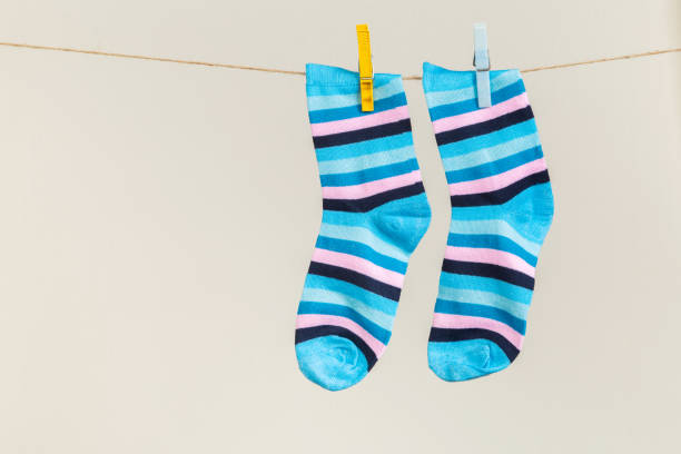 istock multicolored socks, dry after washing, hanging on a clothesline with clothespins on a light background 1289412726