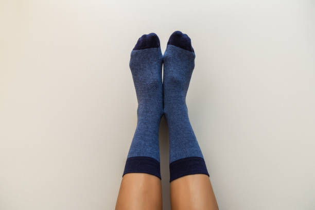 istock female legs in new blue socks on a light beige background 1289412744