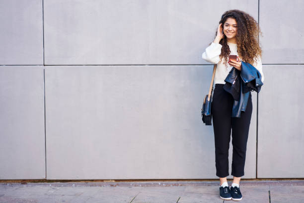 istock Cheerful woman browsing smartphone on street 1289415591