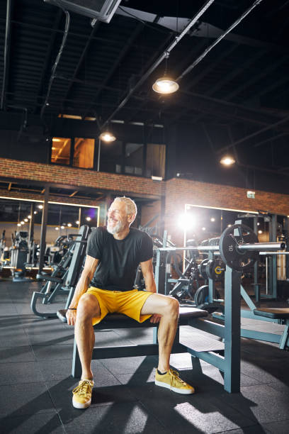 istock Joyous smiling bearded gray-headed bodybuilder looking away 1289415641