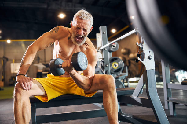 istock Mature bodybuilder yelling during the weight-lifting exercise 1289415709