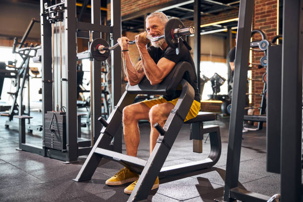 istock Cheerful gray-haired man performing the biceps exercise 1289415816