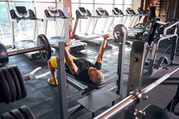 istock Lying sportsman grasping the barbell with both hands 1289415834